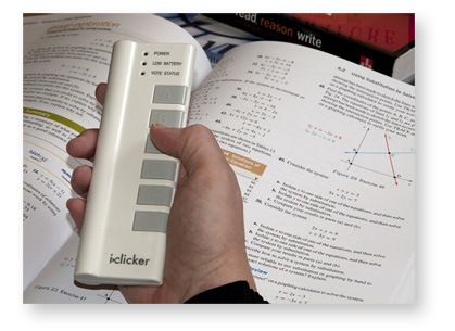 Closeup of hand holding an iClicker polling device.