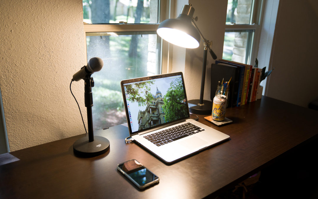 desk with microphone, computer and light